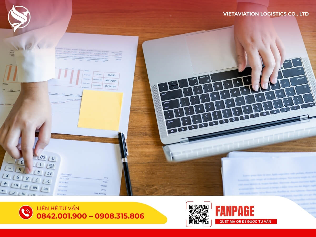 Nhân viên sử dụng máy tính và máy tính cầm tay để tính toán chi phí vận chuyển hàng Trung Quốc uy tín.