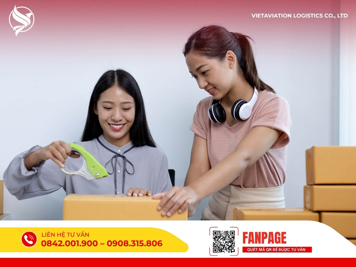 Hai cô gái đang đóng gói và dán băng keo lên thùng carton để chuẩn bị gửi hàng đi Trung Quốc.