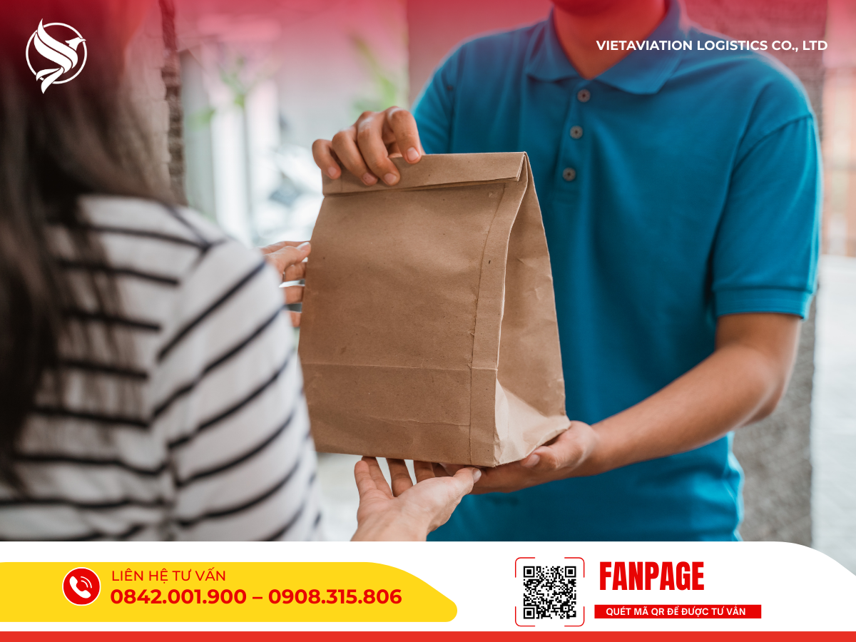 Nhân viên giao hàng đang trao tận tay gói hàng cho người nhận.v