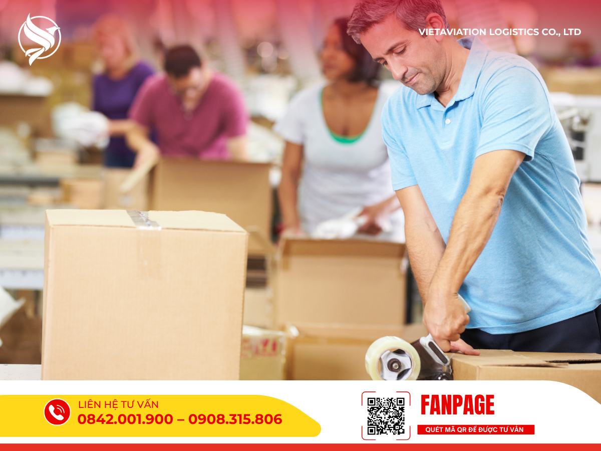 Người đàn ông đang dùng băng keo dán thùng carton để gửi hàng.