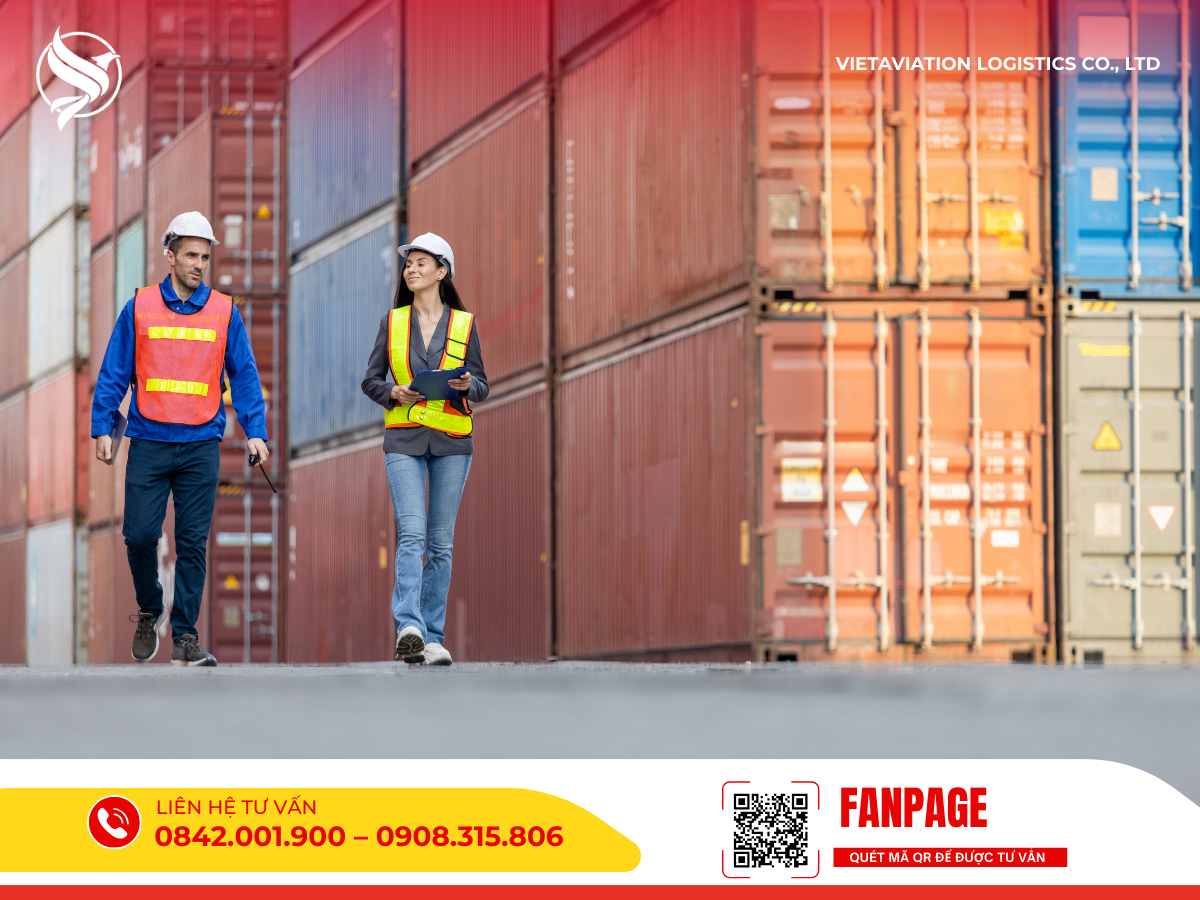 Hai nhân viên logistics đang đi thực địa và rà soát tài liệu tại bãi container, giám sát chặt chẽ quy trình quá cảnh hàng hóa.