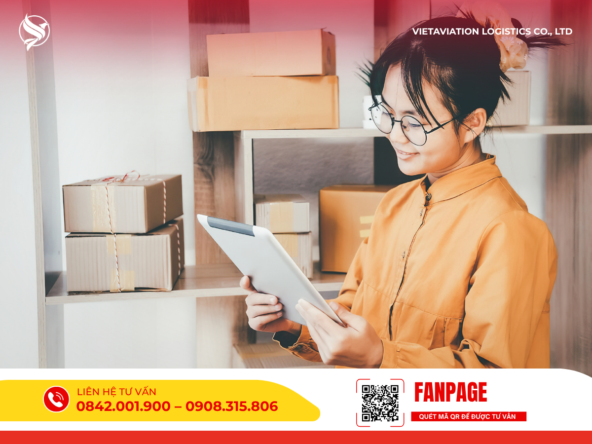 Hình ảnh một người phụ nữ trẻ đeo kính, búi tóc cao và mặc áo màu vàng cam đang mỉm cười xem thông tin trên máy tính bảng, phía sau là chiếc kệ xếp các thùng carton bưu kiện nhỏ gọn.