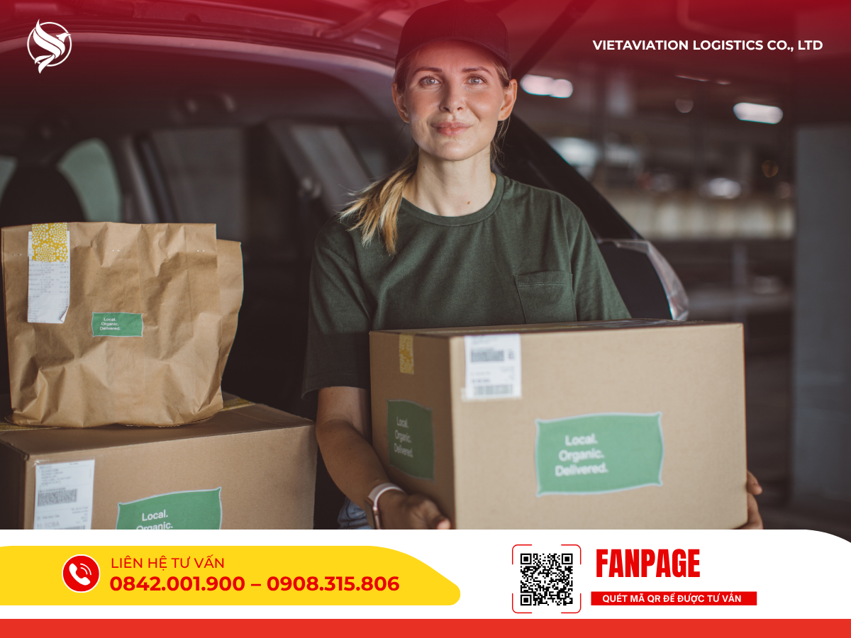 Hình ảnh nữ nhân viên đang ôm thùng carton đứng trước cốp xe giao hàng.