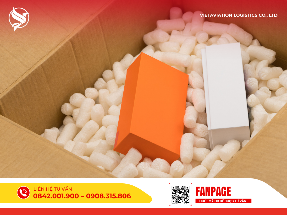 Hình ảnh cận cảnh bên trong một thùng carton được lấp đầy bởi các hạt xốp chống sốc màu trắng nhằm bảo vệ an toàn cho hai hộp hàng nhỏ màu cam và màu trắng ở giữa.