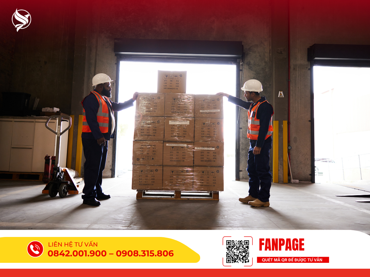 Hình ảnh hai nhân viên kho bãi mặc đồng phục bảo hộ đang cẩn thận kiểm tra một pallet chứa các thùng hàng được quấn màng co an toàn trước cửa xuất hàng.