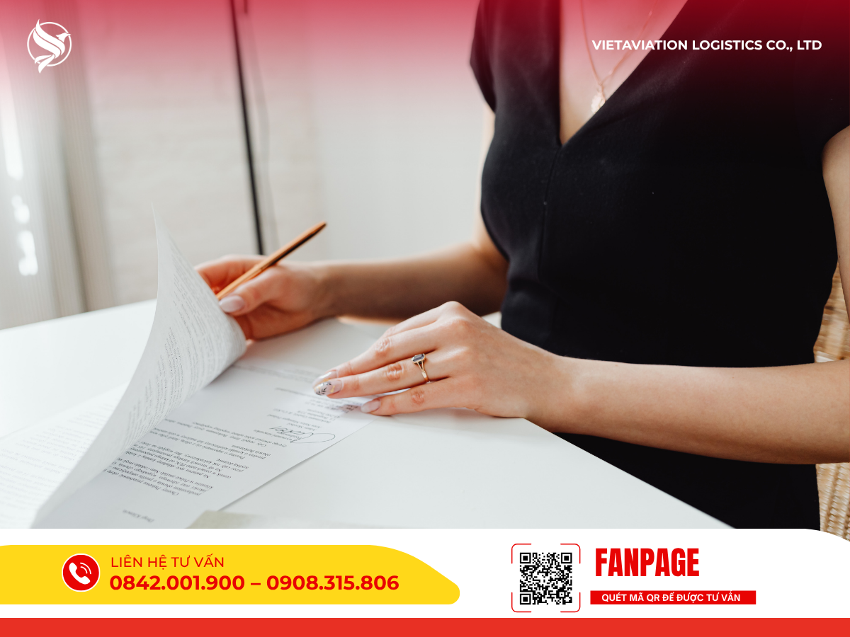 Hình ảnh người phụ nữ đang cầm bút rà soát và kiểm tra cẩn thận từng trang tài liệu trên bàn làm việc.